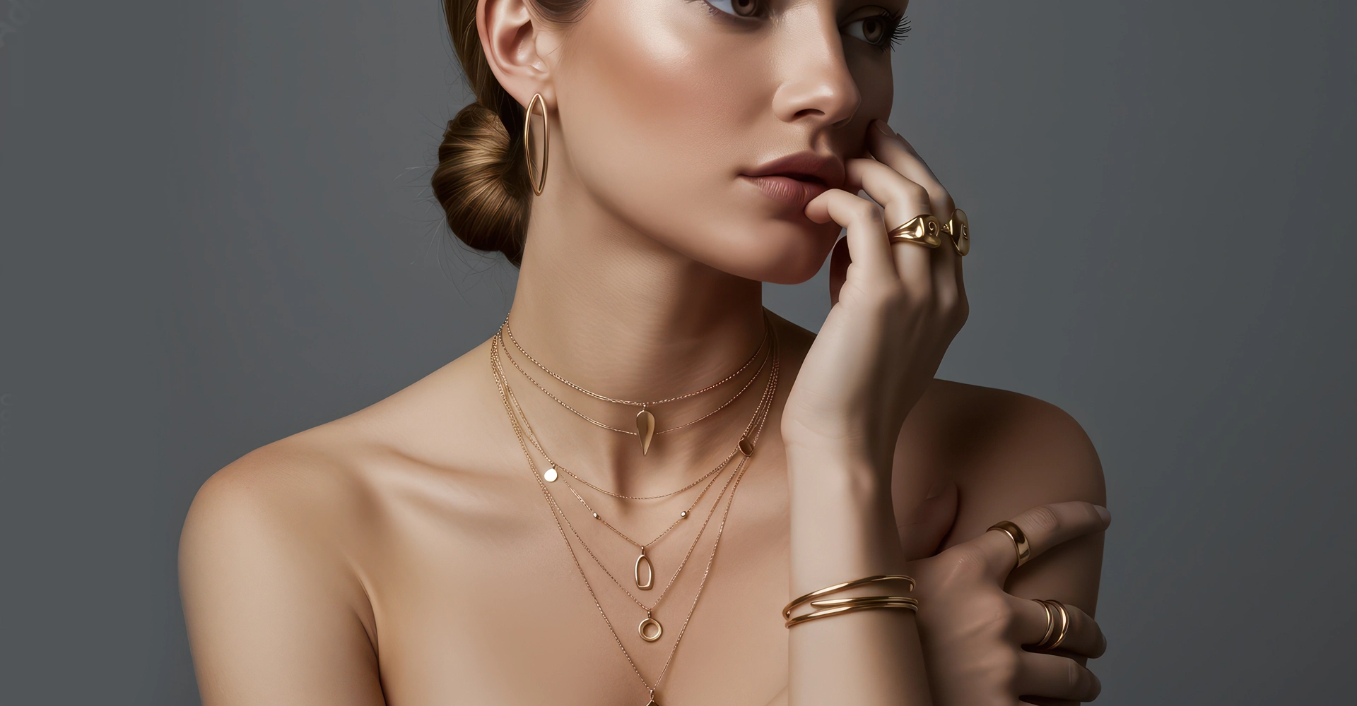 woman wearing layered gold chains bold rings and a subtle makeup look