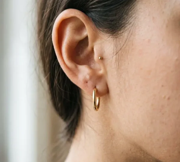 Gros plan sur une oreille avec des boucles d'oreilles élégantes dans une lumière douce et naturelle