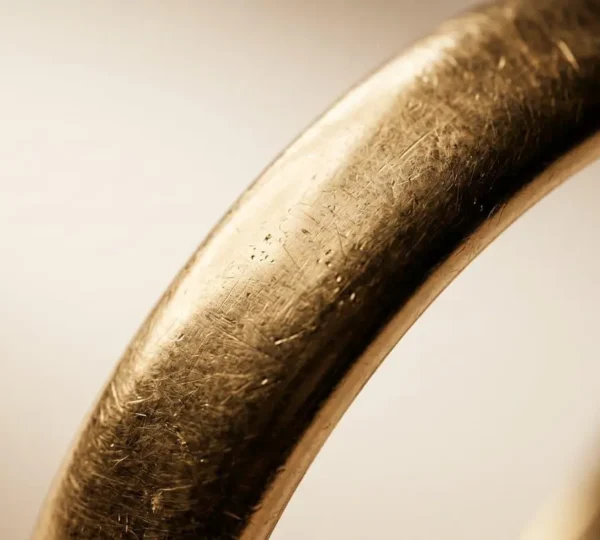 Gros plan macro d'une alliance en or 18 carats révélant sa texture et son éclat profond