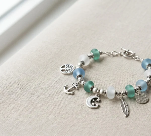 Composition harmonieuse d'un bracelet à charms sur fond minimaliste mettant en valeur l'équilibre visuel